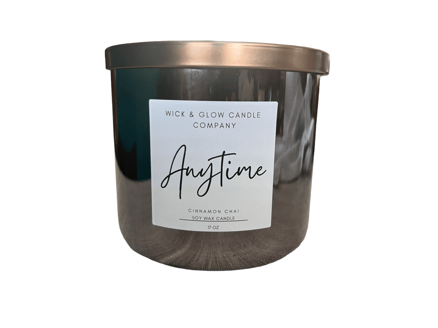 Candle in black jar with white label and bronze lid