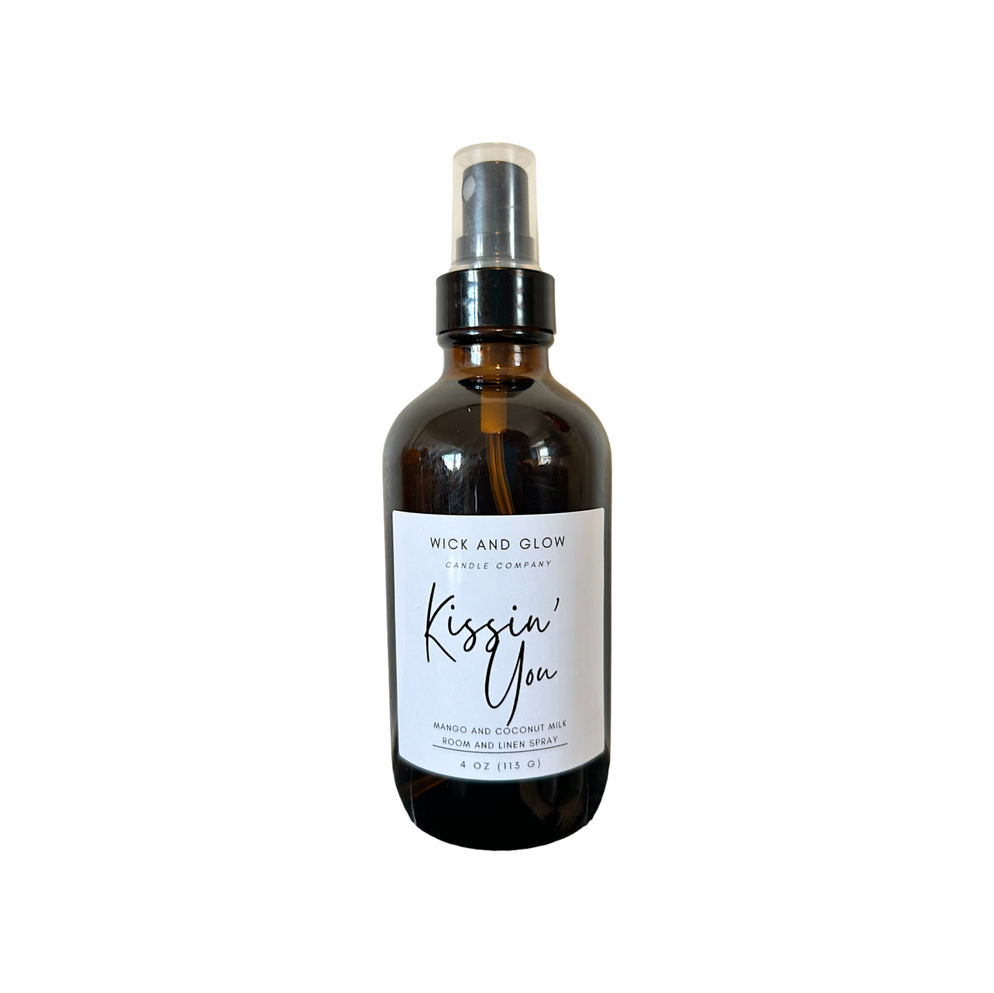 Amber spray bottle with a white label from the Wick and Glow Candle Company on a white background ; the scent is mango and coconutmilk