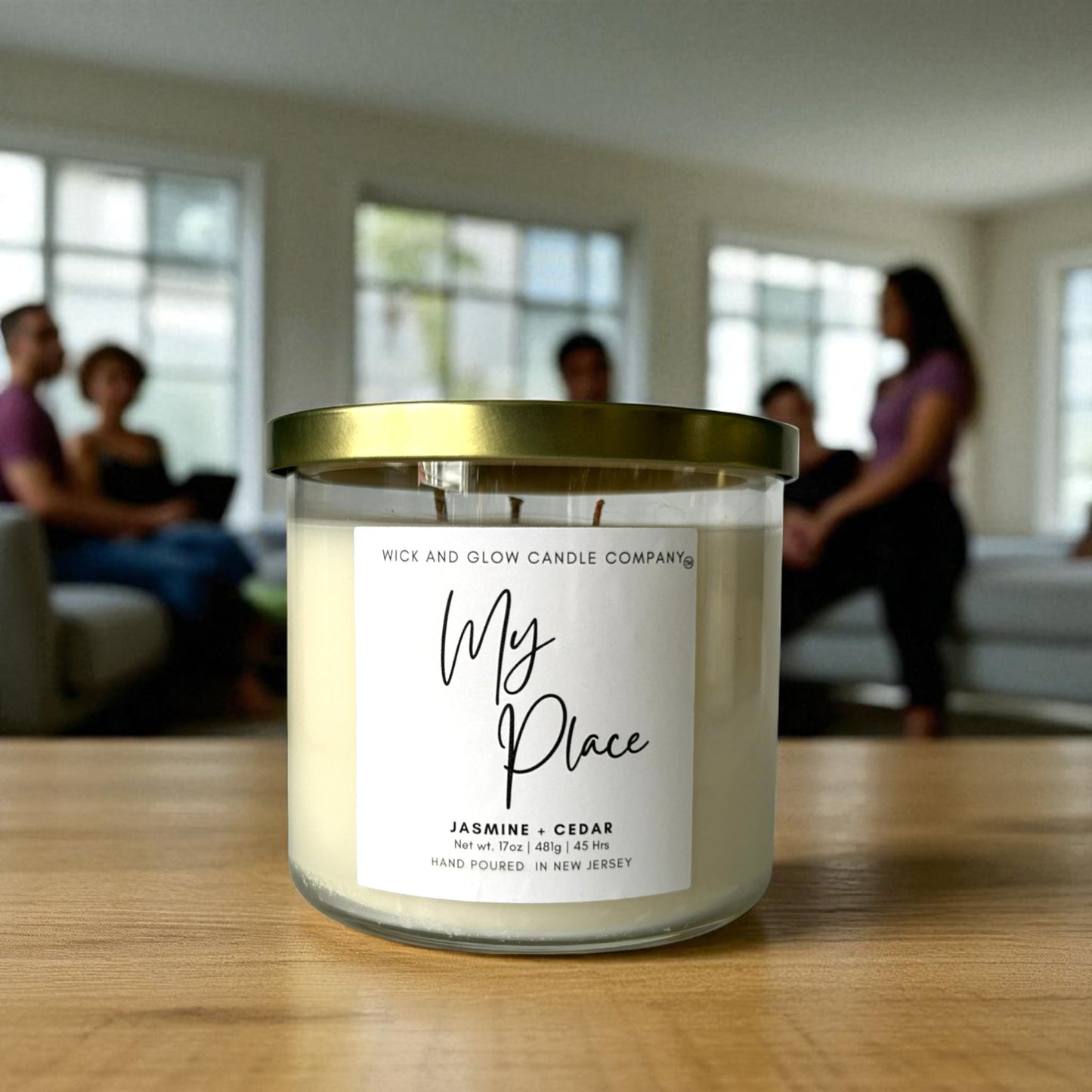 Candle with 'My Place' label on a wooden table, people in the background