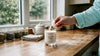 Person lighting clean beauty soy candle in kitchen