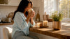 Woman smelling an unlit candle indoors