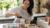 Artisan dipping candle into fragrance oil