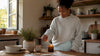 Woman lighting candle on console table