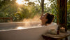 Woman relaxing in candlelit bath with diffuser