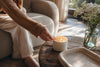 Hand lighting candle on wood table