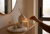 Hand lighting candle in cozy neutral room