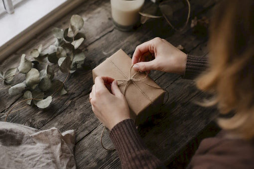 Hands tying twine bow on handmade gift