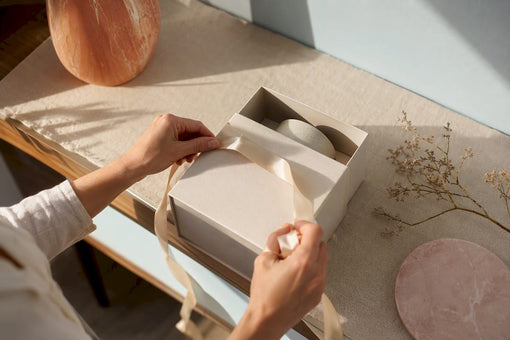 Hands arranging a personalized anniversary candle gift