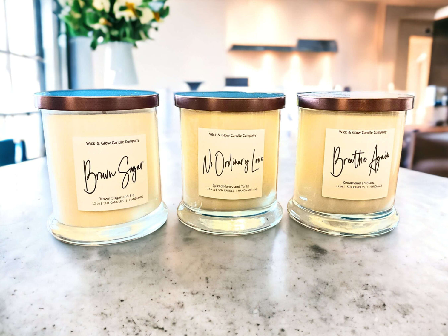 3 candles in clear jars with white labels and bronze lids