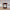 Brown candle with a label on a wooden surface, blurred background