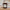Candle with a label on a wooden surface, with a blurred background