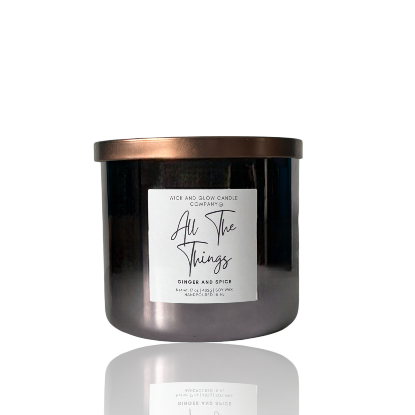 Wick and Glow luxury soy wax candle in a gray glass container with a bronze lid on a white background. The scent is Ginger and spice