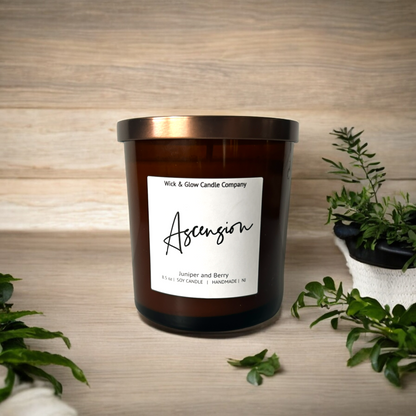 Amber glass jar candle with bronze lid labeled 'Ascension', offering a juniper and berry aroma
