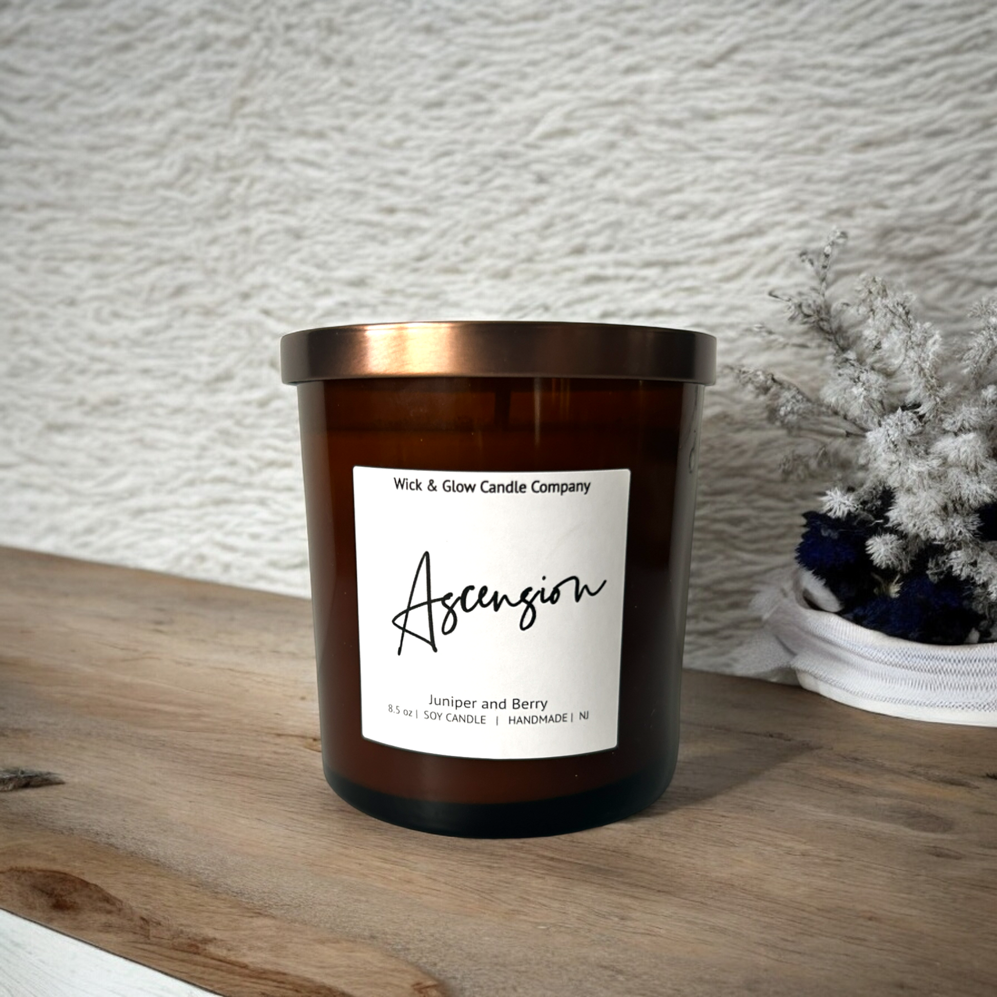 Wick and Glow luxury soy wax candle in an amber glass container on a wooden table with a white background. The scent is Juniper and Berry.