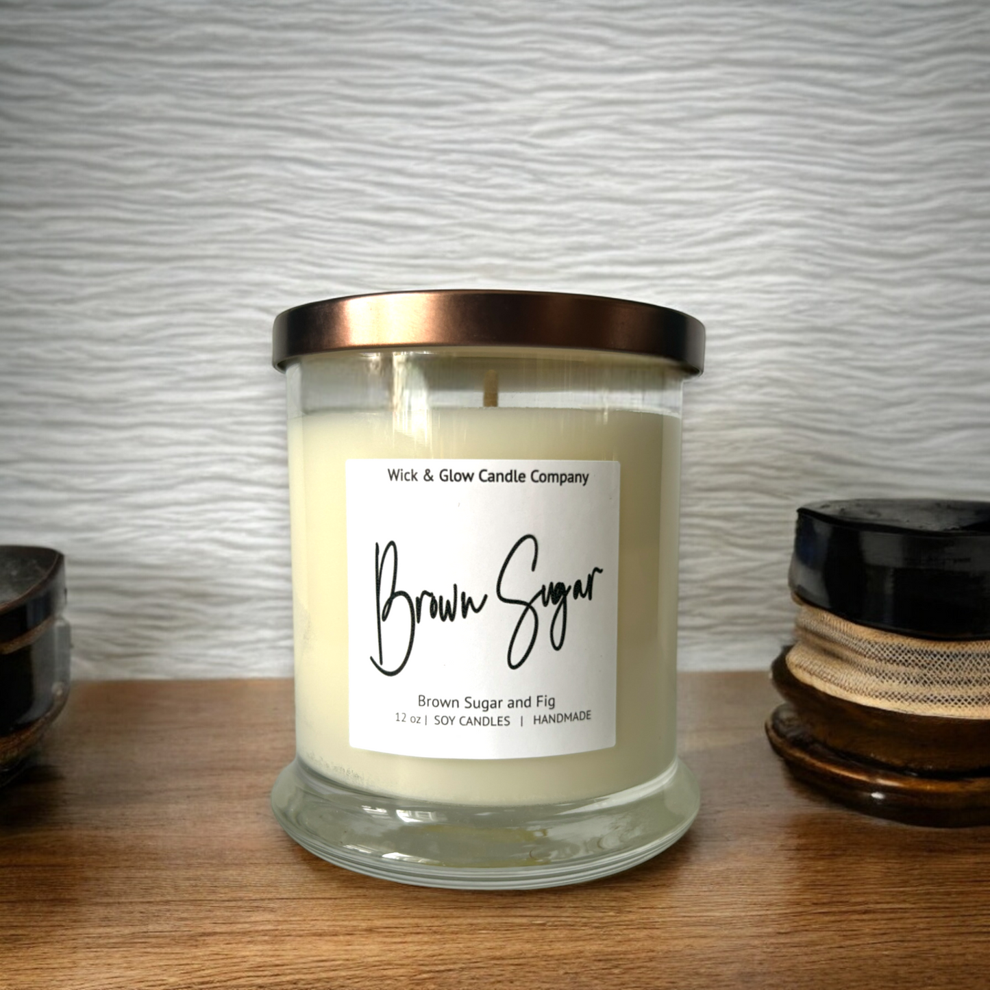 Wick and Glow's luxury soy wax candle in a clear glass container on a wooden table.