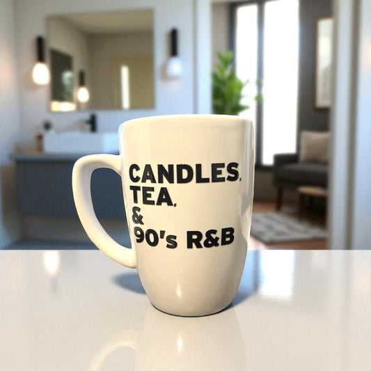 White mug with text 'CANDLES, TEA, & 90's R&B' on a kitchen counter.