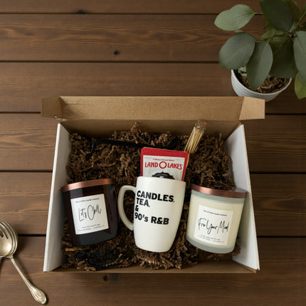 Gift set with mugs, candles, and tea包 in a box on a wooden surface.