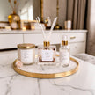 Decorative items including a candle, diffuser, and bottle on a marble surface with a blurred background.