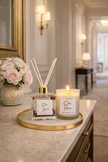 Candle and diffuser set on a marble surface with a decorative background