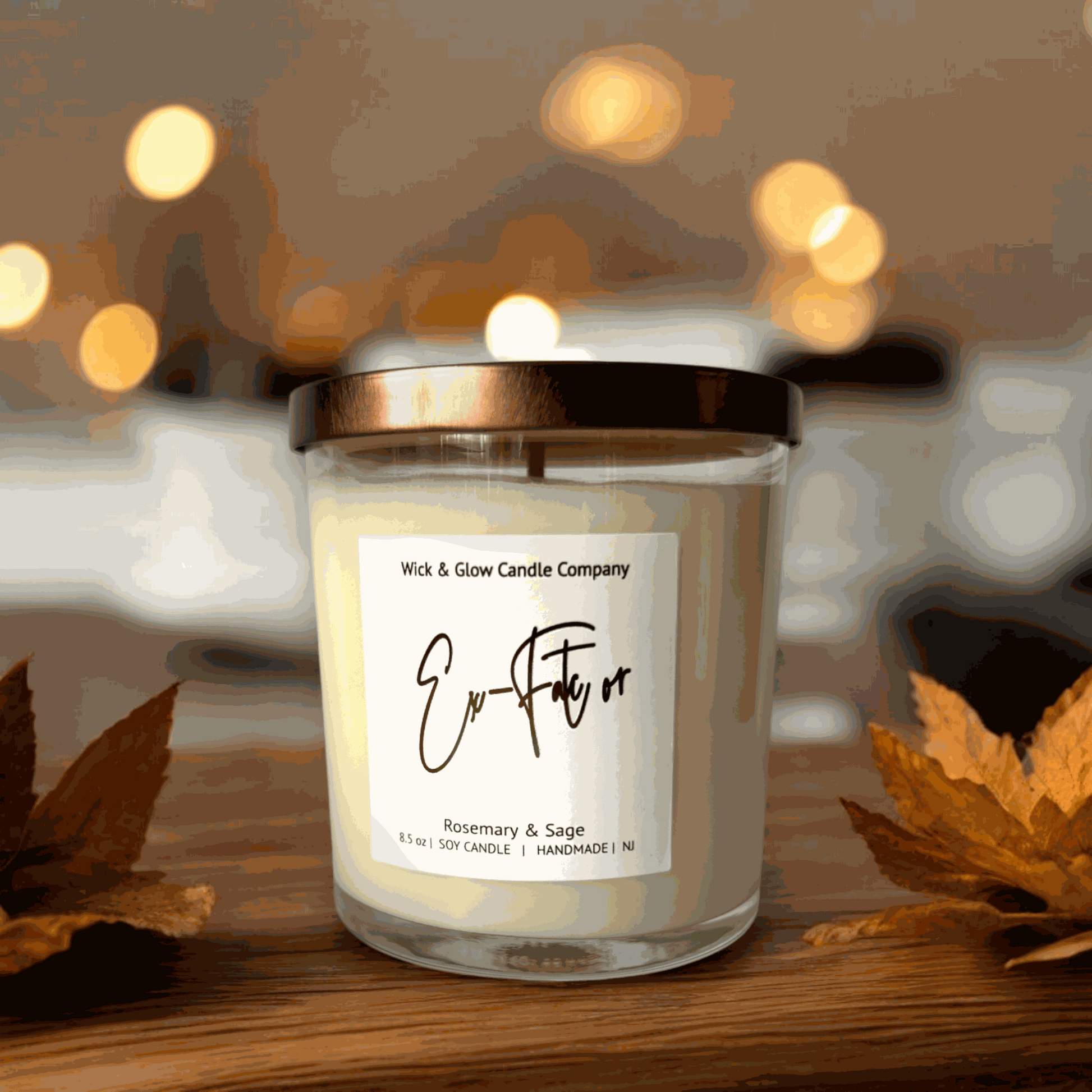 Rosemary and sage soy wax candle in a clear glass jar with a bronze lid on a rustic wooden table with a glowing background.