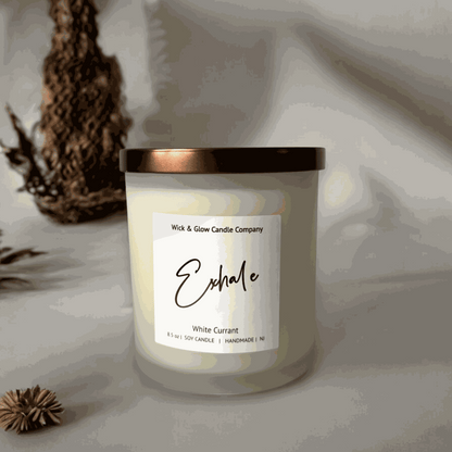 White currant soy wax candle in a frosted white glass jar with a bronze lid on a white table with on a white background from Wick and Glow Candle Company