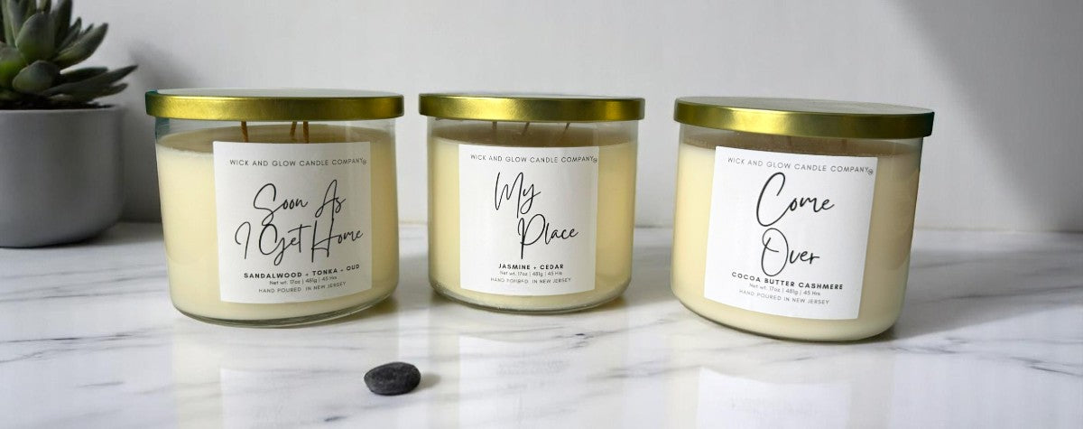 Luxury three wick soy candles by Wick and Glow on a marble table, hand-poured and non-toxic with a sleek, modern design