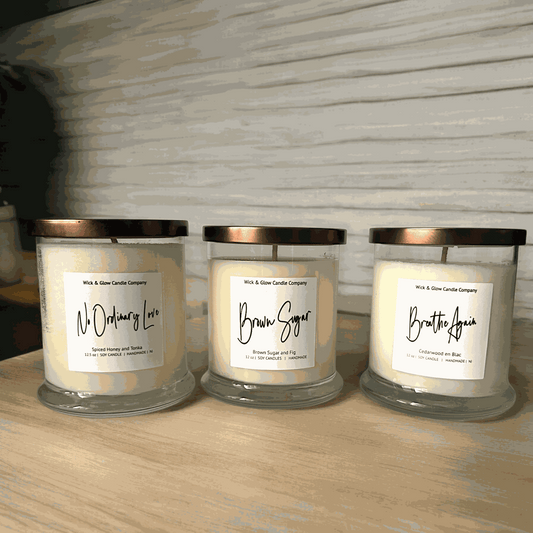 3  candles in clear jars with gold lids and white labels from Wick and Glow Candle Company with a white background. Scents are Brown Sugar and fig, Cedarwood and Spiced Honey