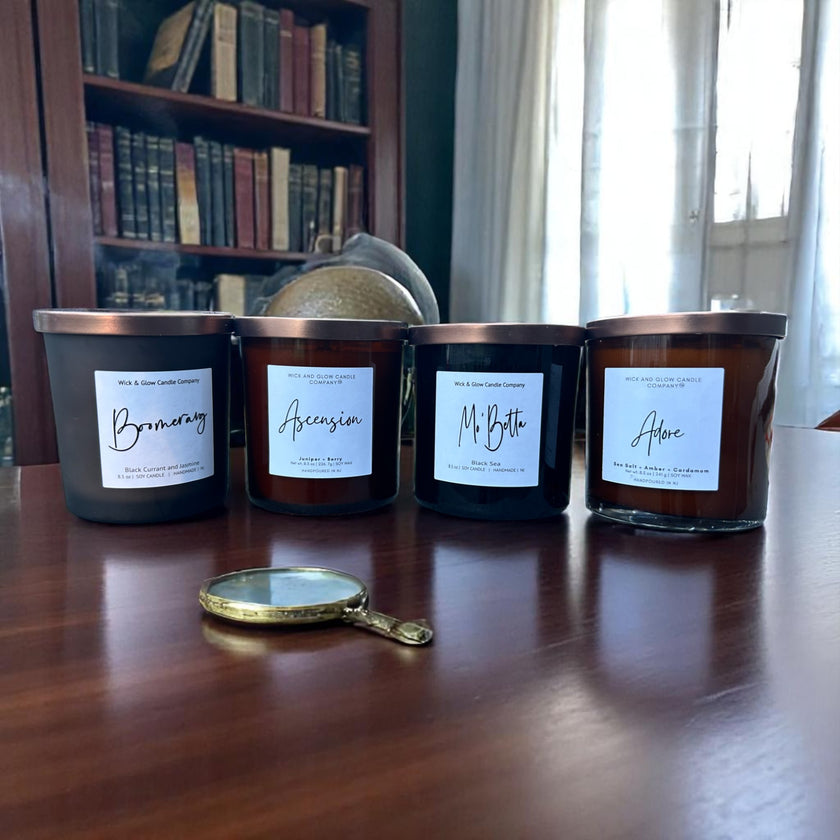 Four candles with labels on a wooden surface, with a magnifying glass in front.