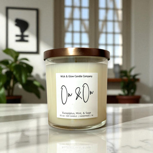 Candle with a label on a marble surface, with plants and a window in the background