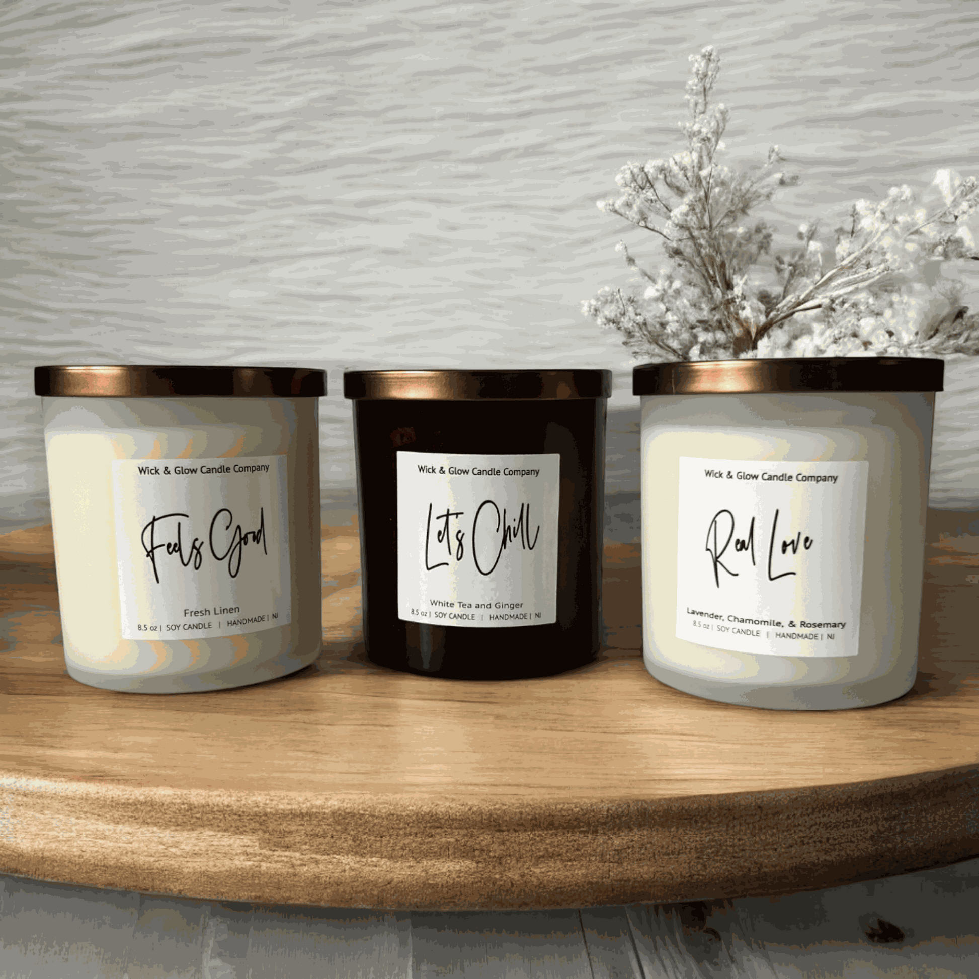 Three luxurious soy wax candles with bronze lids displayed on a rustic wooden table, perfect for setting a warm, inviting ambiance in any room