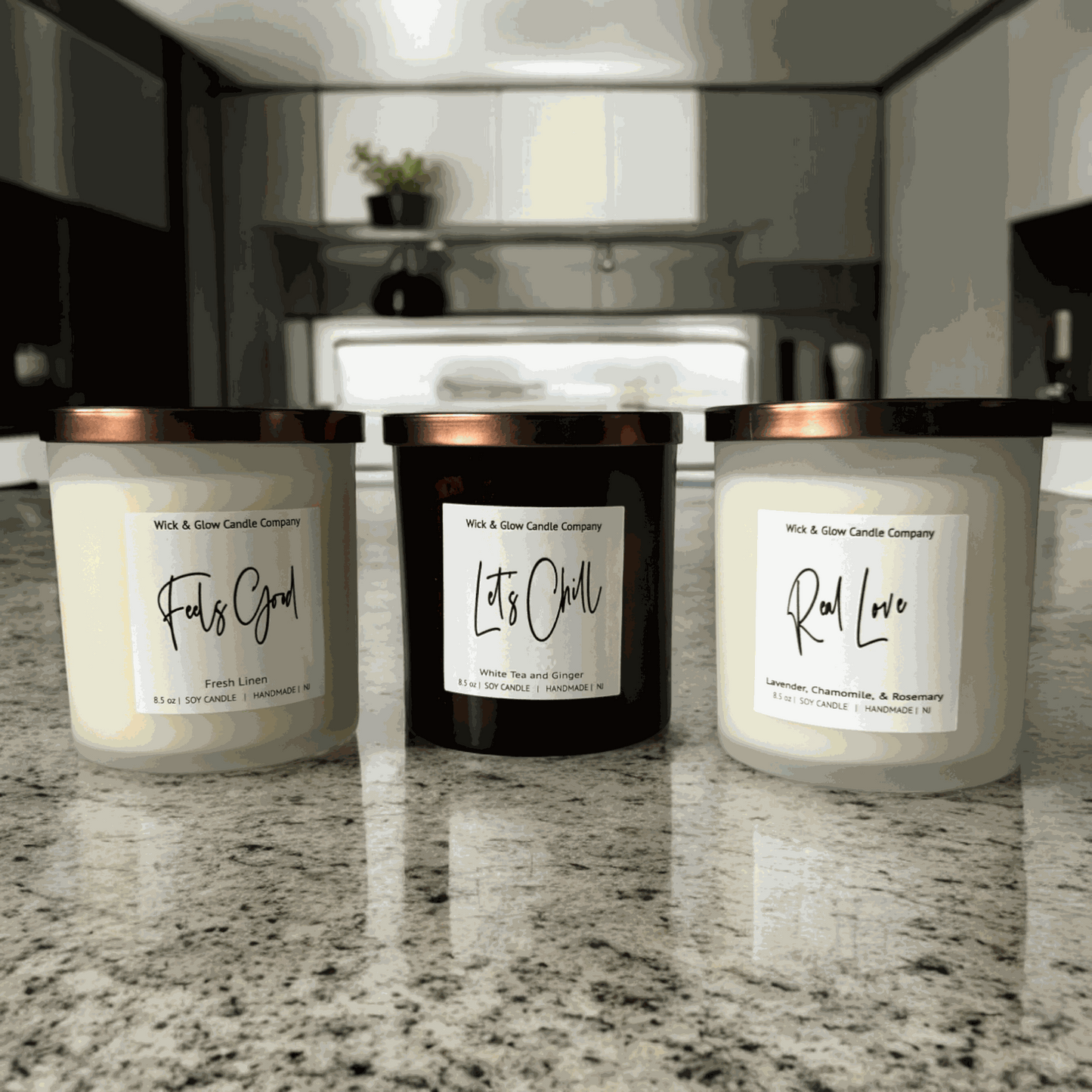 Three luxurious soy wax candles with bronze lids displayed on a marble counter, perfect for setting a warm, inviting ambiance in any room