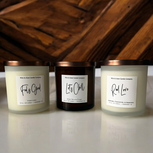 Three Wick and Glow candles in white and amber jars with bronze lids. Lavender candle, fresh cotton candle, white tea and ginger candle. Glow candles.