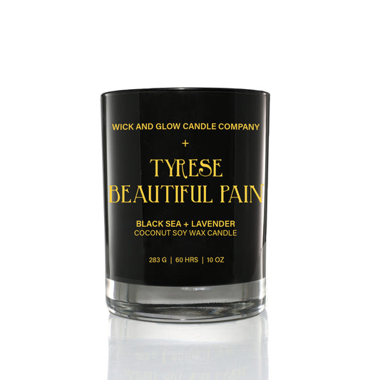 Black candle  jar  from the Tyrese Home fragrance Collection with Wick and Glow Candle Company.  The  jar has the candle name 'Beautiful Pain' written in gold on the jar. The fragrance is Black Sea and Lavender