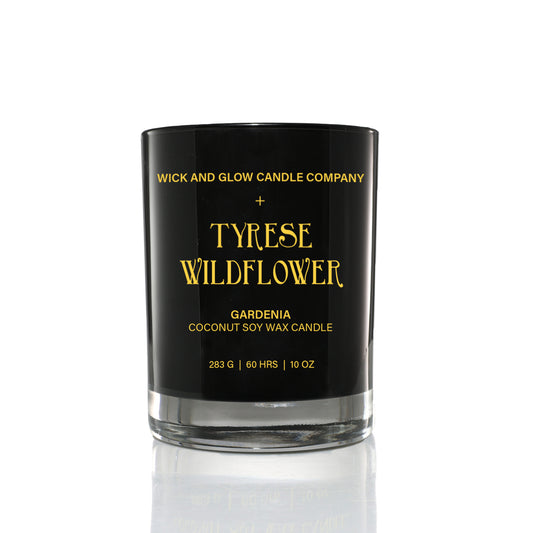 Black candle  jar  from the Tyrese Home fragrance Collection with Wick and Glow Candle Company.  The  jar has the candle name 'Wildflower' written in gold on the jar