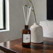 Aromatherapy diffuser with reeds on a wooden surface, with a blurred background