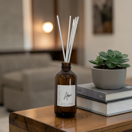 Aromatherapy diffuser with reeds on a wooden table in a living room setting.
