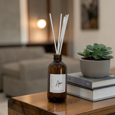 Aromatherapy diffuser with reeds on a wooden table in a living room setting.