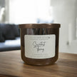 Wick and Glow Candle Company® Sweetest Thing cinnamon chai soy wax candle in a brown glass jar on a wooden table