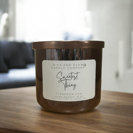 Wick and Glow Candle Company® Sweetest Thing cinnamon chai soy wax candle in a brown glass jar on a wooden table