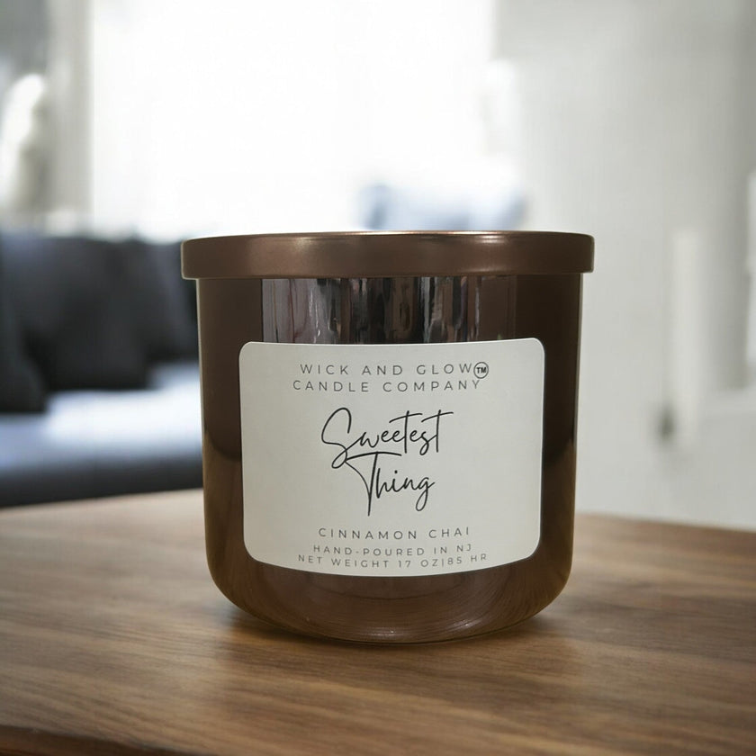 Wick and Glow Candle Company® Sweetest Thing cinnamon chai soy wax candle in a brown glass jar on a wooden table
